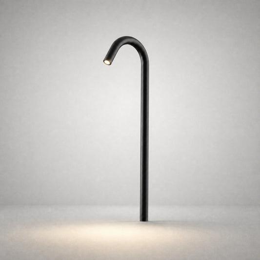 Black matte ground light with sleek cylindrical pole projecting warm LED beam