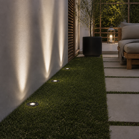 Dark matte black recessed outdoor spotlight DECK PRIME 1677 installed in artificial grass casting warm white light
