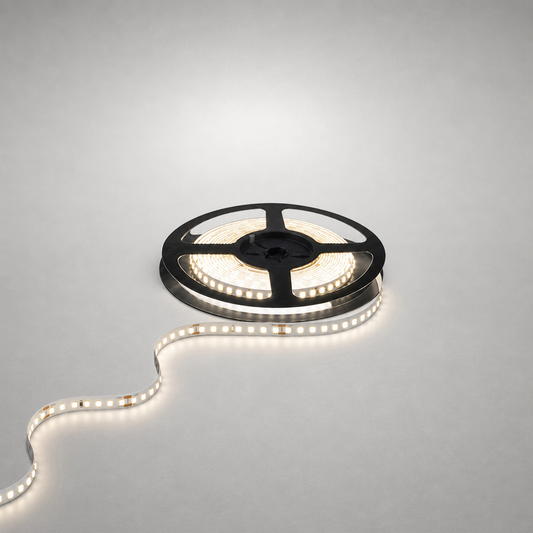 Coiled warm white 14.4W IP20 LED strip light on black spool with visible SMD LEDs and copper pads