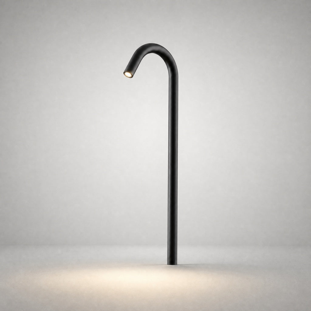 Black matte ground light with sleek cylindrical pole projecting warm LED beam