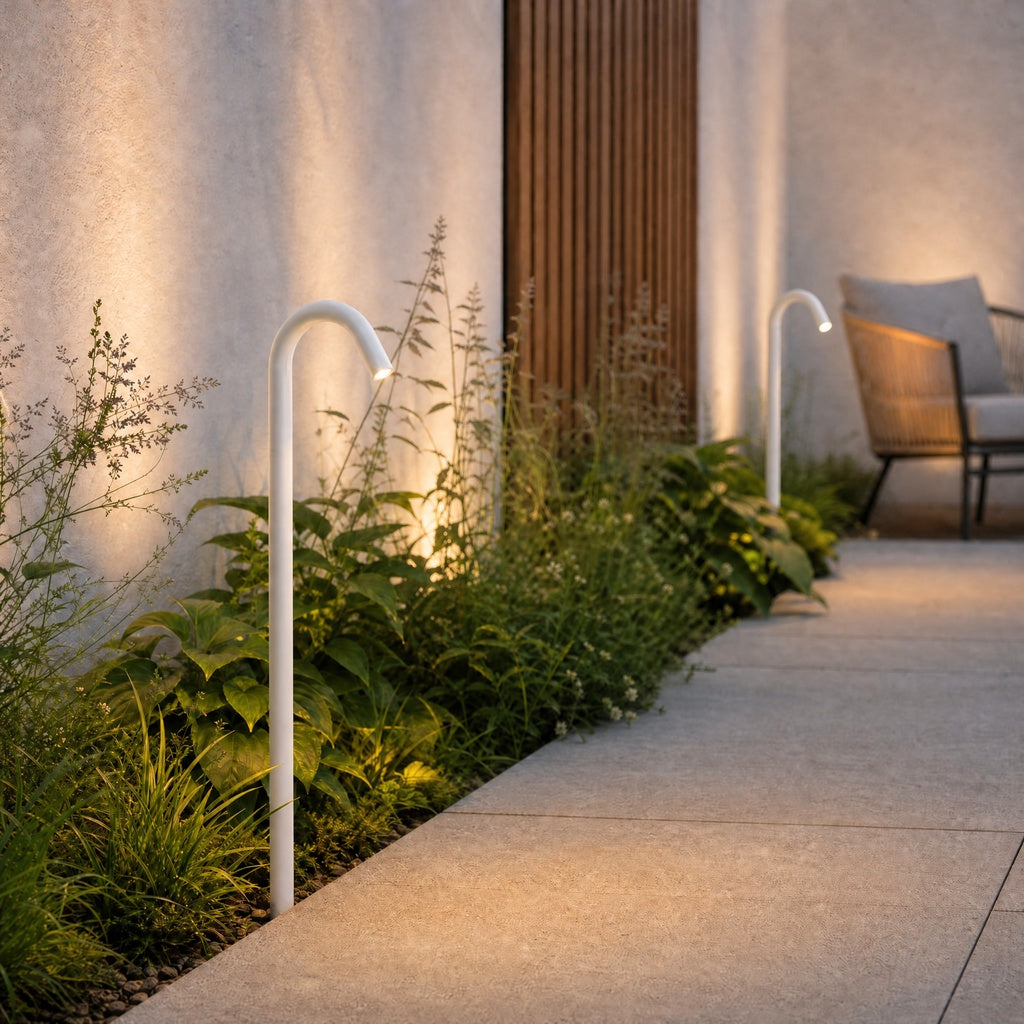 White matte outdoor path light illuminating landscaped patio and stucco wall