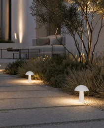 white mushroom path lights illuminating stone garden pathway at dusk