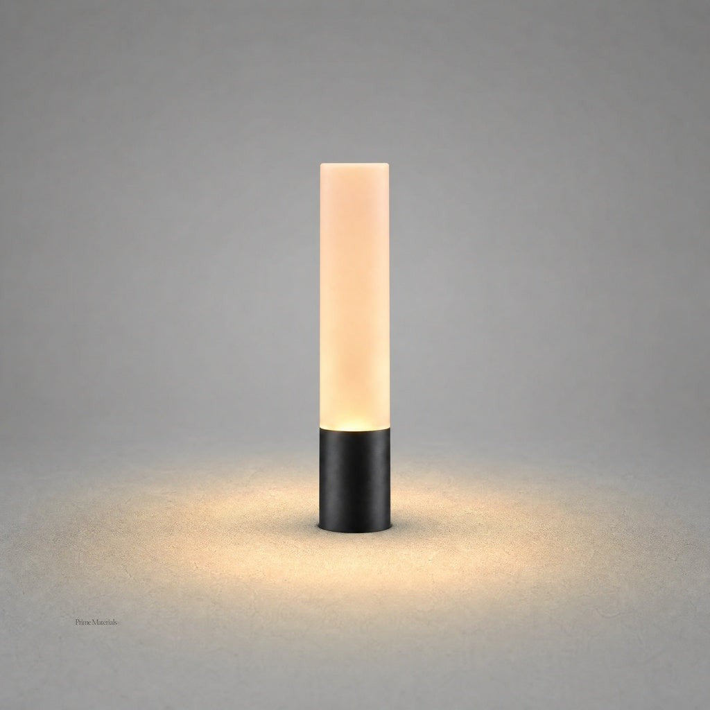 Matte black cylindrical outdoor stake light with frosted diffuser emitting warm white glow