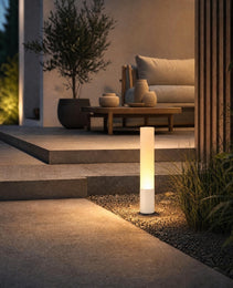 White outdoor garden stake light illuminating gravel path beside concrete steps at night