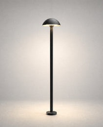 Black powder-coated metal bollard light with hemispherical dome shade on studio background