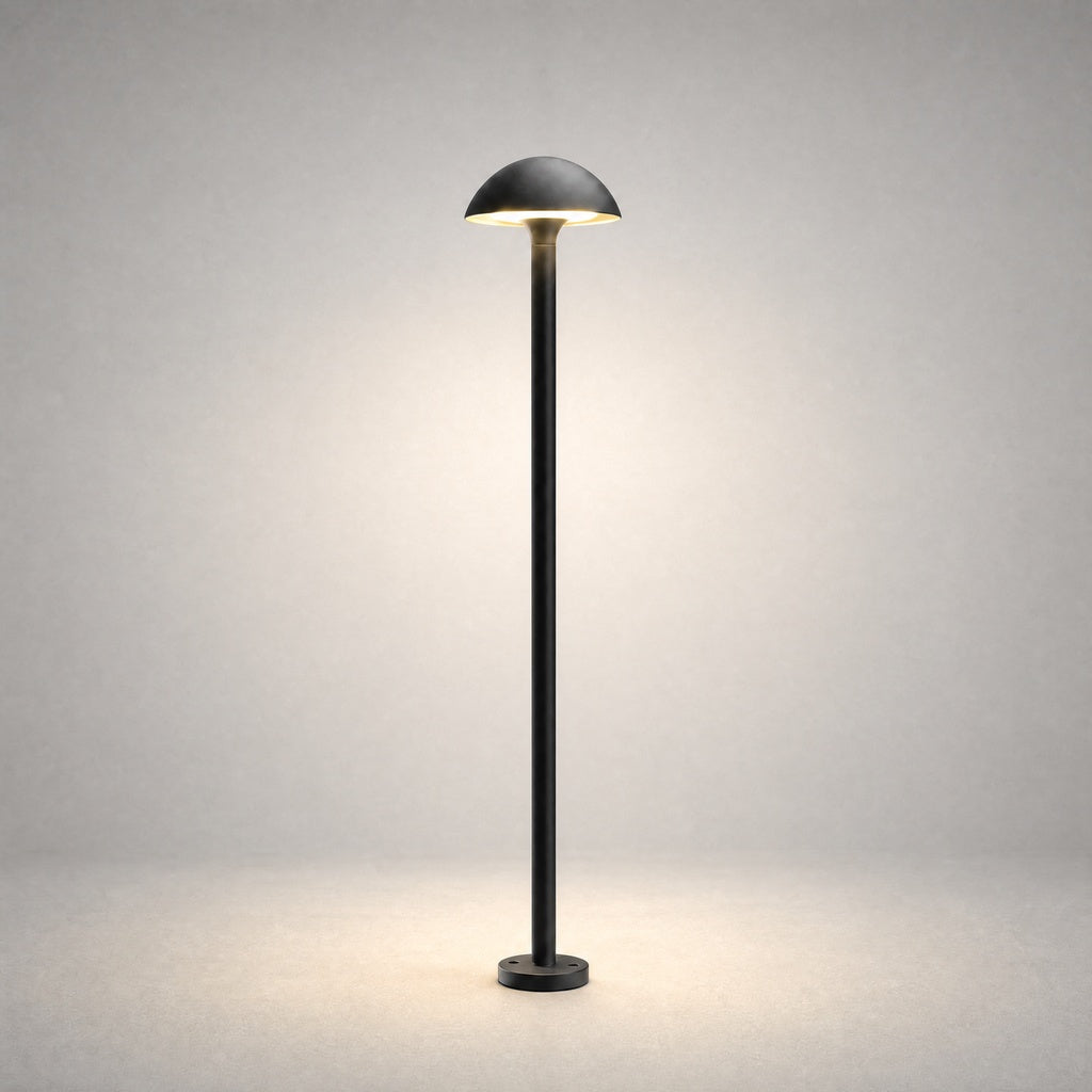 Black powder-coated metal bollard light with hemispherical dome shade on studio background