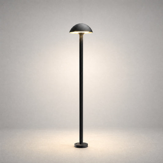 Black powder-coated metal bollard light with hemispherical dome shade on studio background