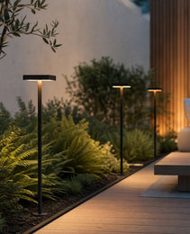 Black matte DC24V outdoor bollard light with square top illuminating garden pathway beside wooden deck