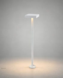 White geometric square-top bollard lamp with warm glow on neutral studio background