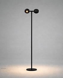 Black matte mobile projection floor lamp front view showing dual cylindrical heads and oval warm light footprint