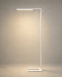 White matte C-shaped floor lamp with horizontal LED bar and U-shaped base against textured wall
