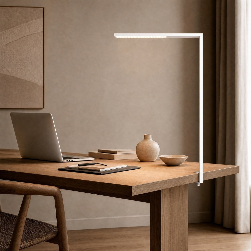 White matte L-shaped floor lamp clipped to oak desk in uncluttered study setting