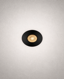 Black GU10 MR16 recessed ceiling light with matte trim and gold reflector casting warm glow