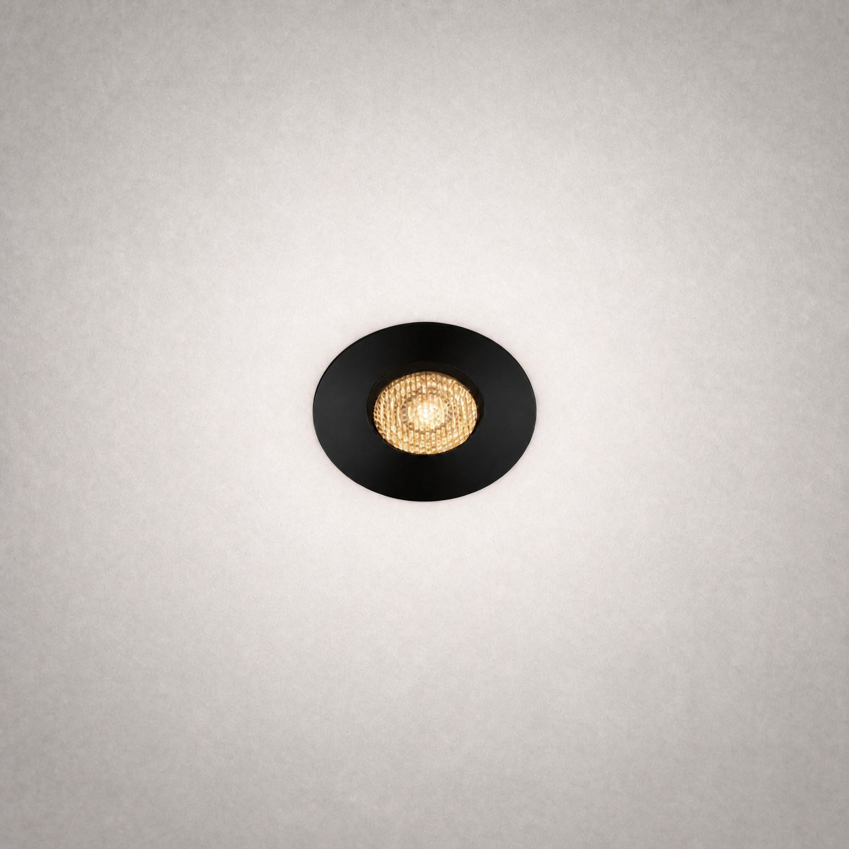 Black GU10 MR16 recessed ceiling light with matte trim and gold reflector casting warm glow