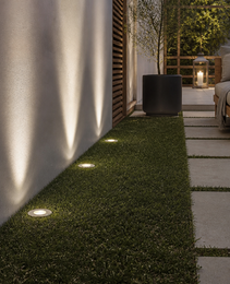 Brushed aluminum trim recessed outdoor spotlight DECK PRIME 1677 embedded in turf next to stucco wall