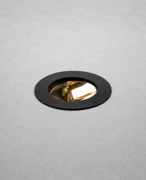 Black matte trim recessed floor light with gold reflector flush mounted in concrete