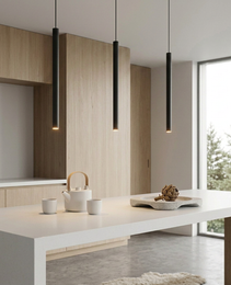 Set of three matte black pendant lights over kitchen island with warm glow