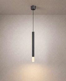 Black vertical linear ceiling suspension luminaire with matte finish casting soft glow on textured beige wall