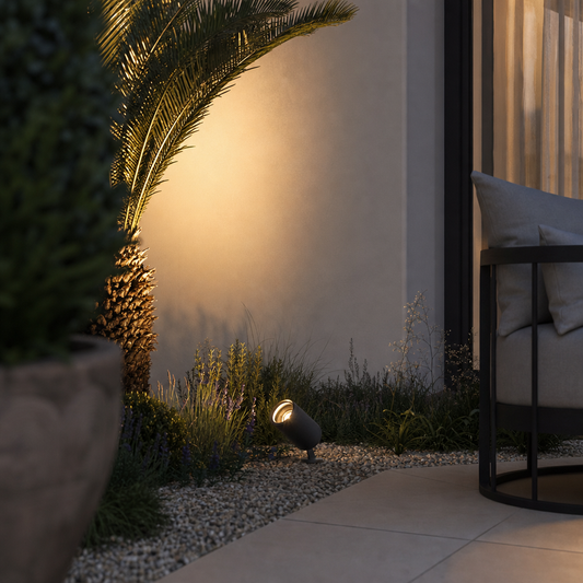 Dark grey textured garden spike light casting warm glow on wall