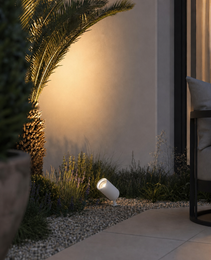 White matte garden spike light illuminating lavender and palm at dusk