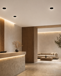 Black flush mount spotlights installed in modern commercial lobby above wooden reception desk