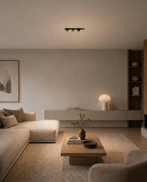 Black recessed LED spotlight fixture illuminating modern beige sofa area