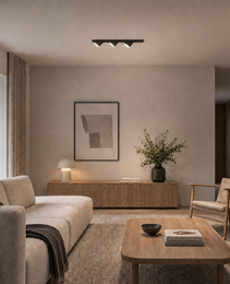 Black recessed ceiling track light with three adjustable spotlights above sofa