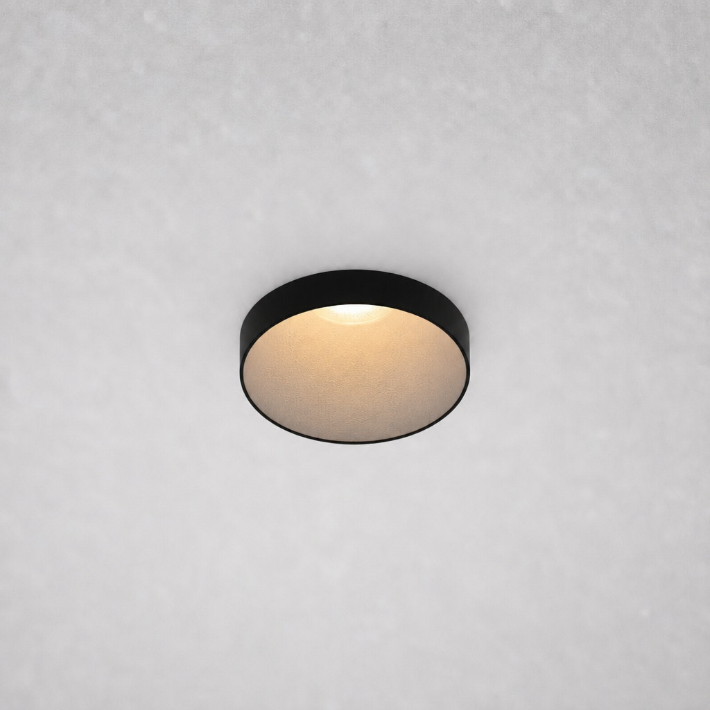 Close-up black ROYCE PRIME 1828 recessed ceiling fixture matte gold-beige reflector emitting soft warm white light