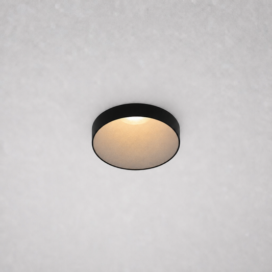 Close-up black ROYCE PRIME 1828 recessed ceiling fixture matte gold-beige reflector emitting soft warm white light