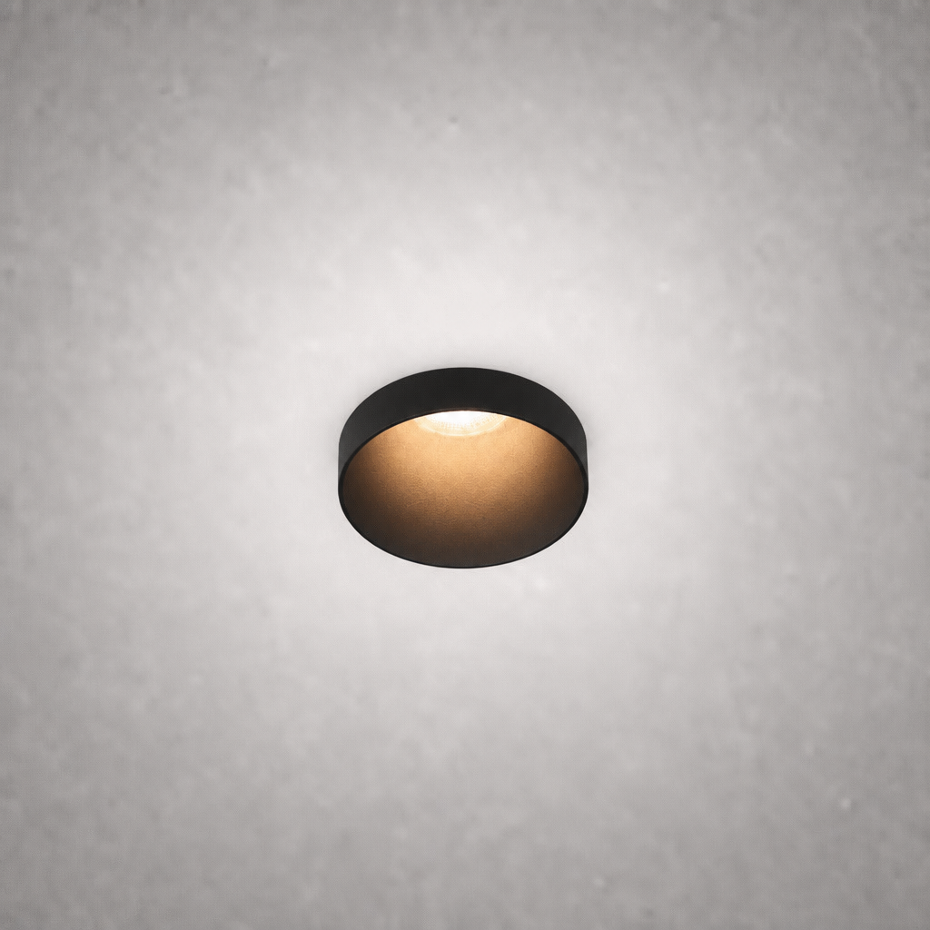 Matte black semi-recessed ceiling spotlight with warm glow on textured gray ceiling