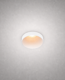 Matte white semi-recessed ceiling spotlight with soft golden light on light gray ceiling