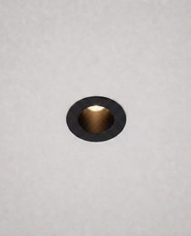 close-up black trim ring DOT PRIME 1839 recessed light with gold reflector on textured ceiling