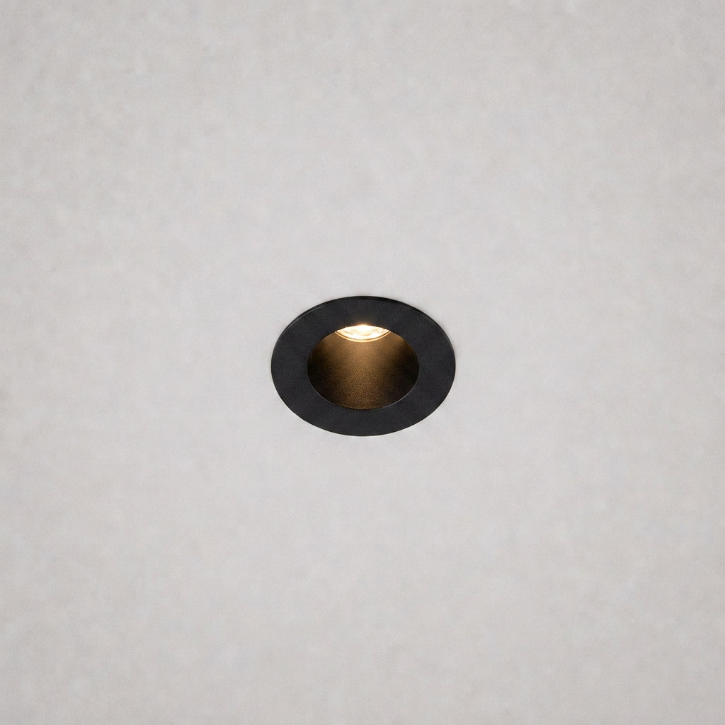close-up black trim ring DOT PRIME 1839 recessed light with gold reflector on textured ceiling