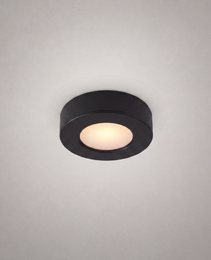 close-up matte black ultra-thin circular surface-mount recessed luminaire with diffused warm white glow