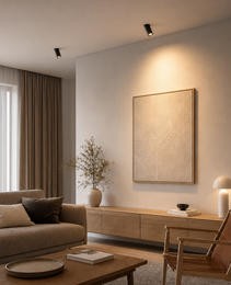 Two black ROBO PRIME 1590 adjustable LED spotlights illuminating abstract art in modern living room