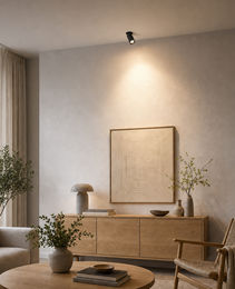 Black adjustable dimmable recessed spotlight in modern living room highlighting wall texture