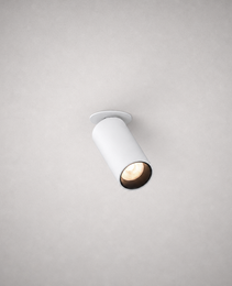 White matte finish recessed adjustable spotlight isolated on gray ceiling with warm LED glow