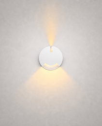 White circular wall fixture with matte finish and dual beam design for clean interior stair illumination