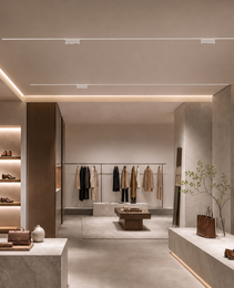 White linear rail lighting system mounted on ceiling for minimalist retail interior
