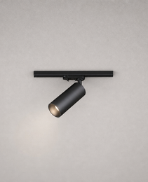 Close-up black matte cylindrical track spotlight showing mounting hardware and warm light