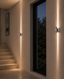 Brushed nickel oval wall sconce with warm white LED beams in residential hallway