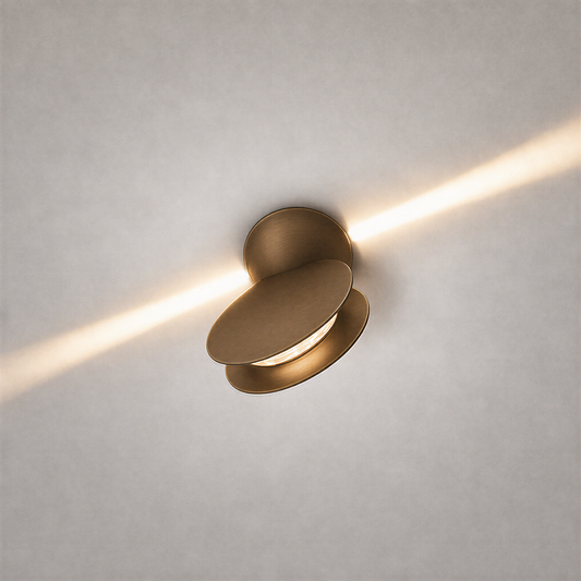 Matte brass oval ceiling light fixture casting diagonal warm beam on textured ceiling
