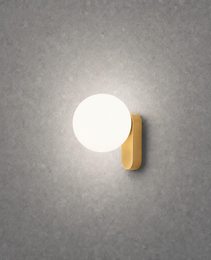 Close-up brushed gold oval wall lamp on textured concrete wall