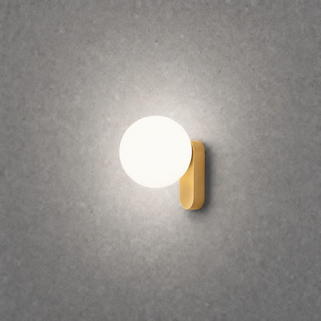 Close-up brushed gold oval wall lamp on textured concrete wall