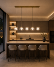Linear row of five Crysta alabaster pendant fixtures with brass canopy above light stone kitchen island