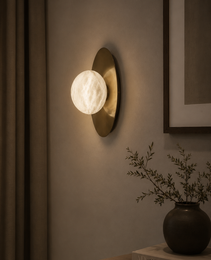 Marsa Wall spherical alabaster sconce with natural veining on matte gold backplate against textured beige wall