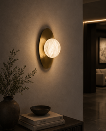 Minimalist alabaster sphere wall light fixture in warm glow as architectural accent for modern hallway